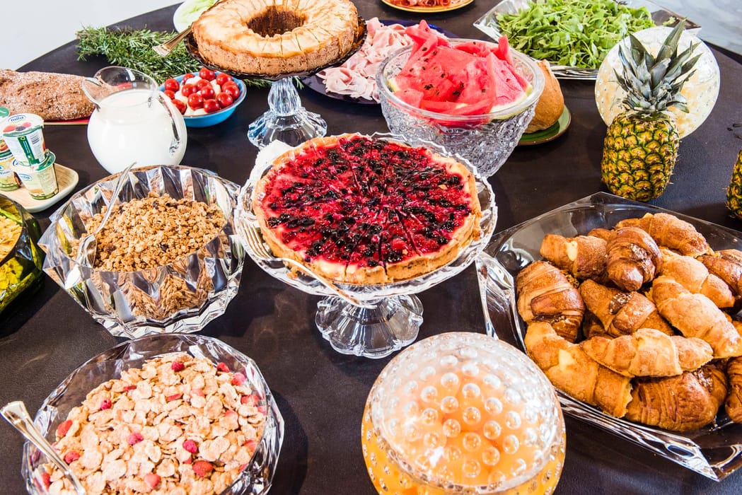 Mesa preparada para el desayuno con pasteles y fruta